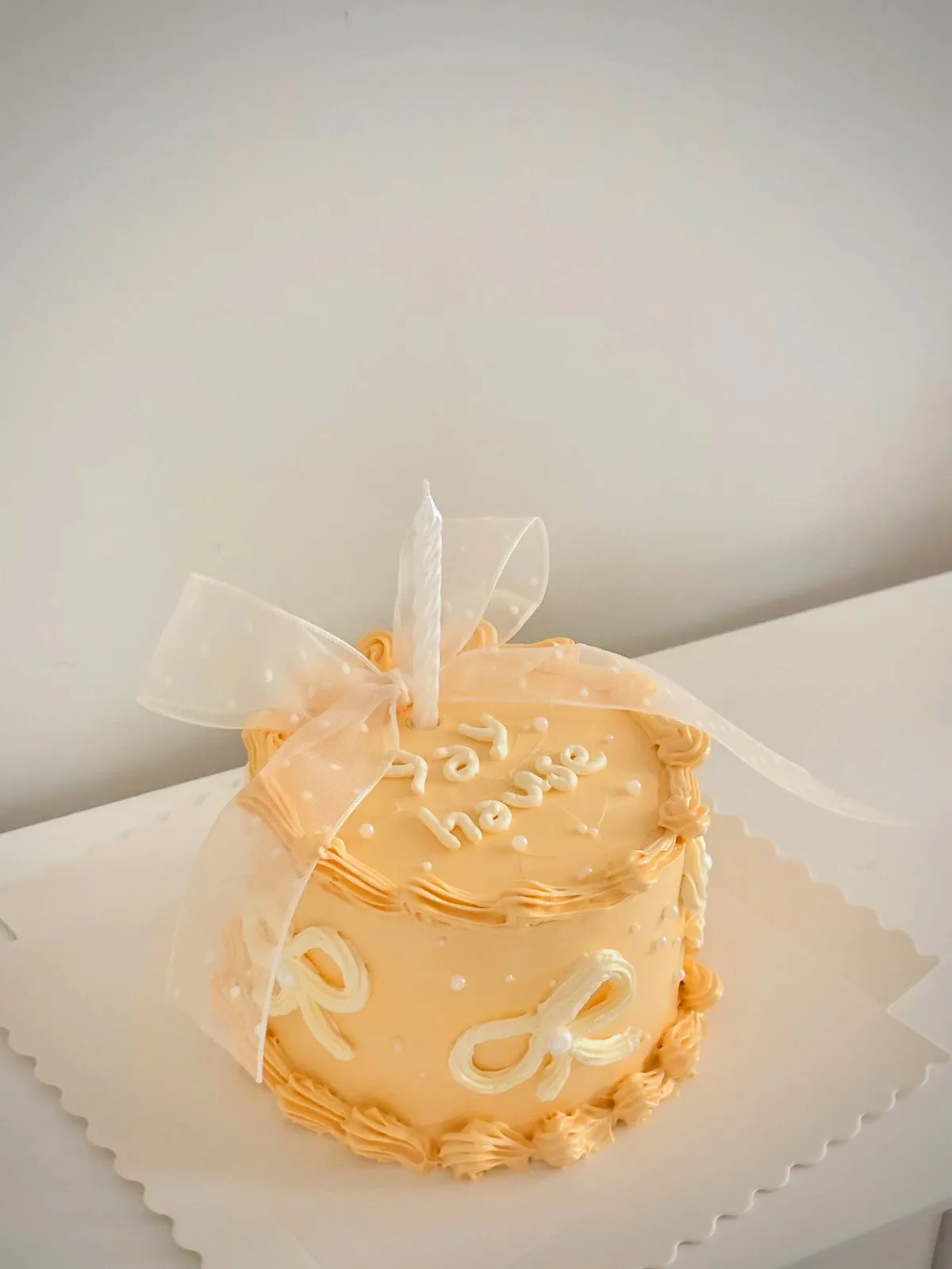 Apricot cake with piped bows and organza ribbon, custom cake made in Streatham SW16 - Danine Cakes