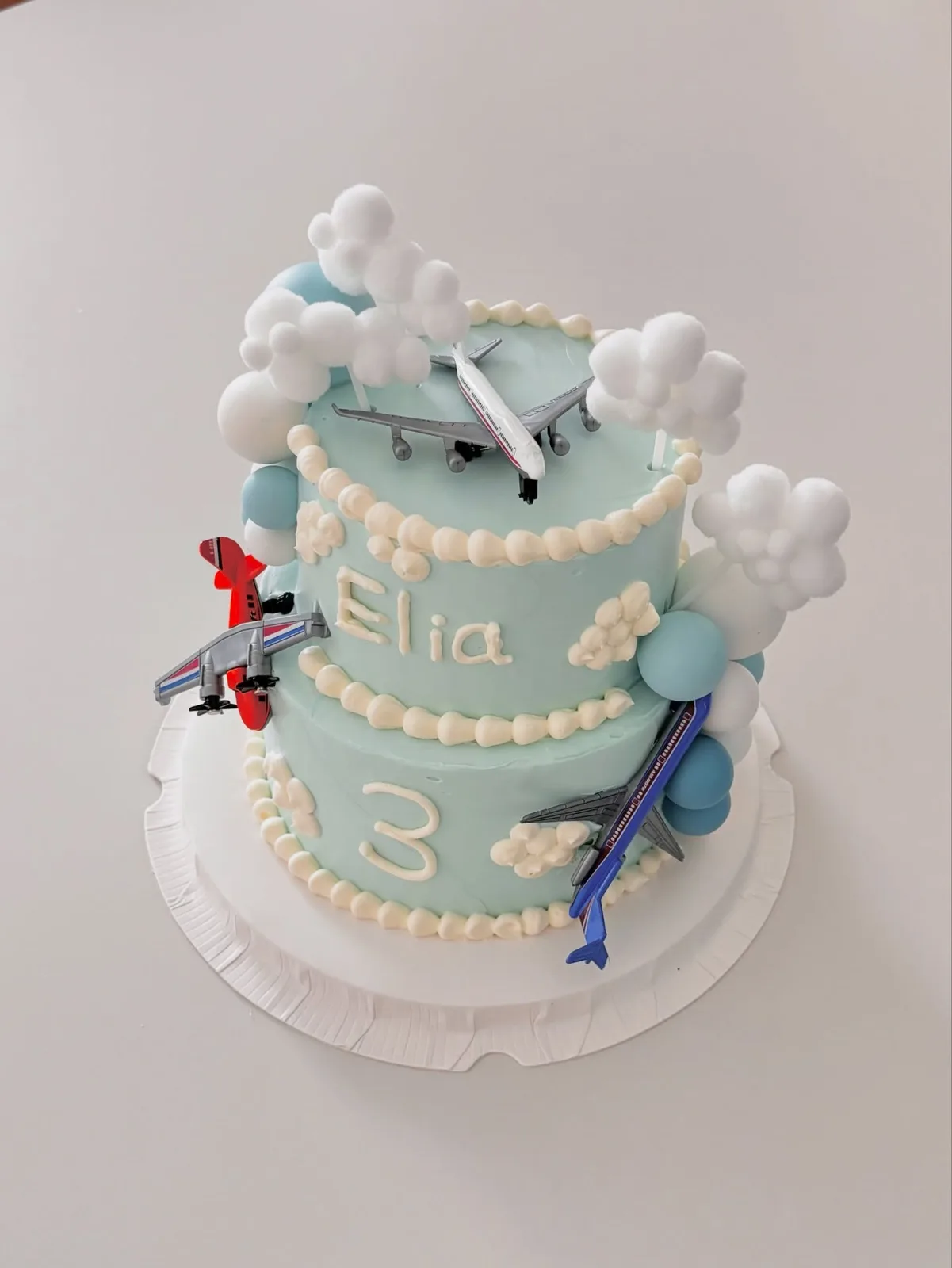 Blue cake with aeroplane and cloud toppers, Korean-inspired custom cake handmade in Streatham, London