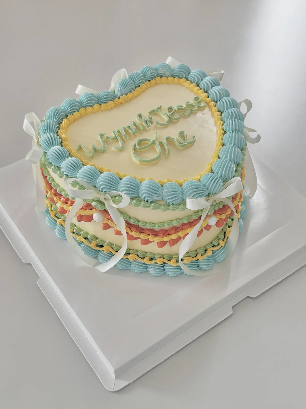 Blue heart cake with multicoloured piped borders, Korean-inspired custom cake handmade in Streatham, London
