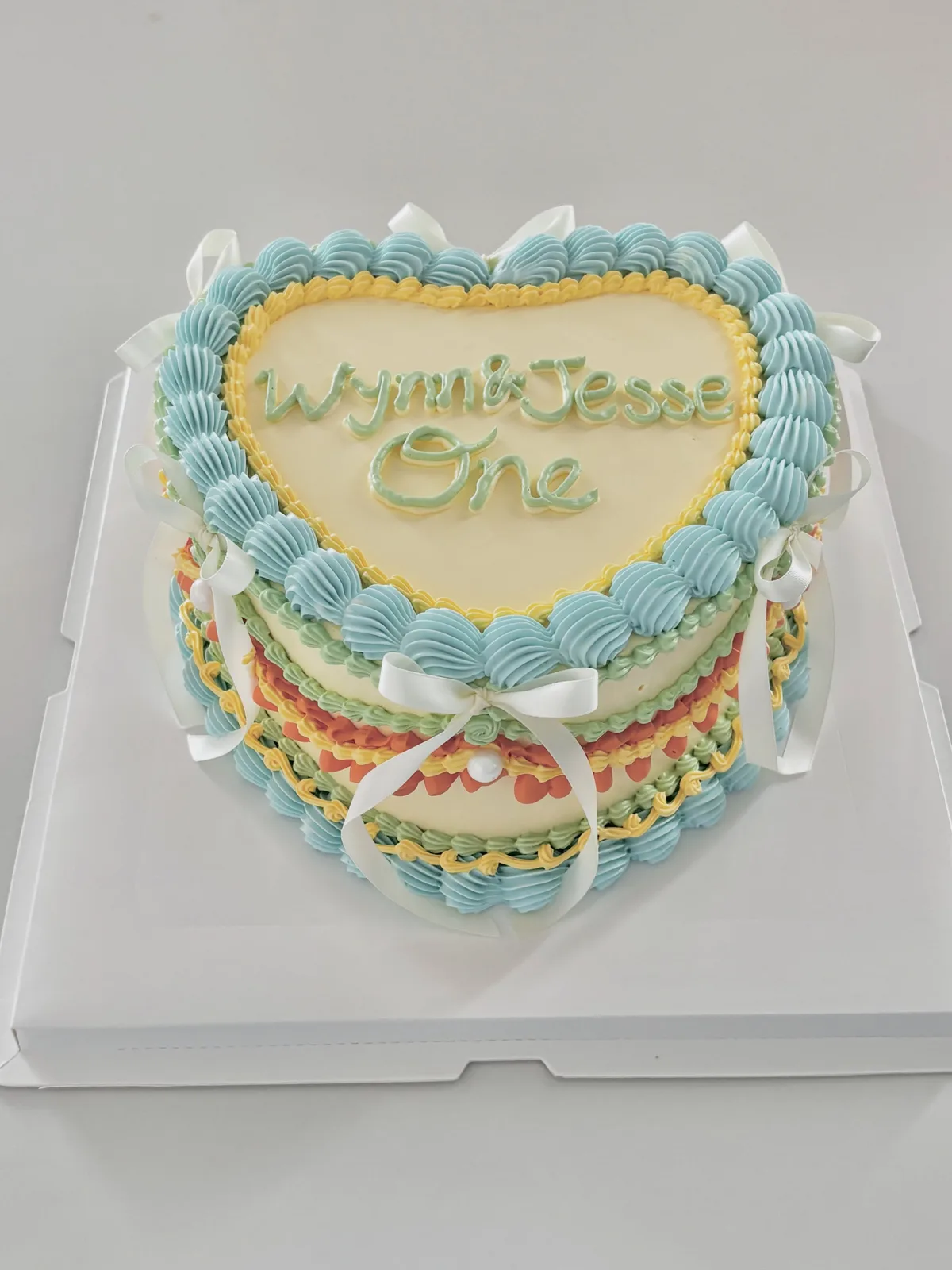 Blue heart cake with multicoloured piped borders, Korean-inspired custom cake handmade in Streatham, London