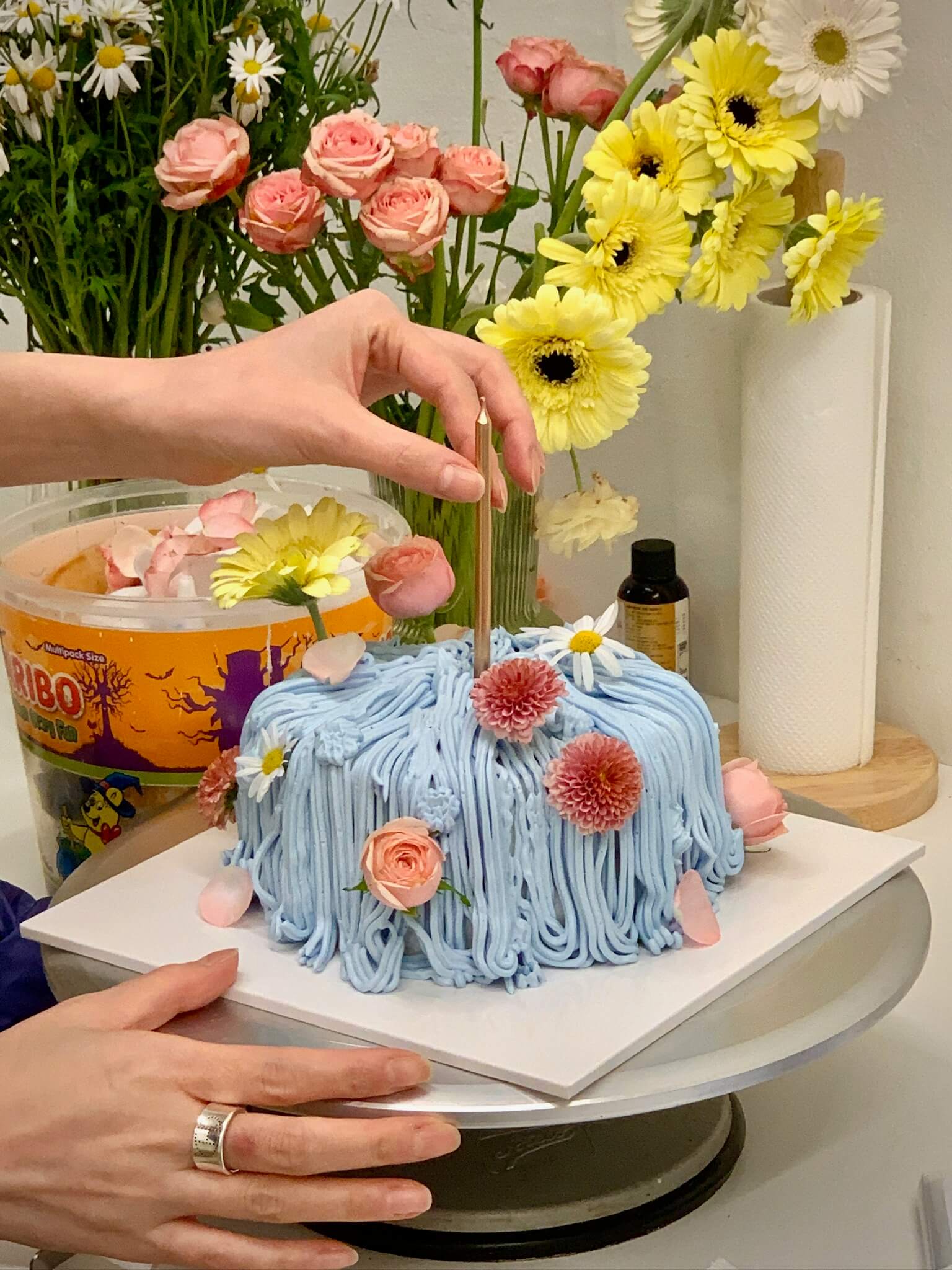 Cake decorating class Streatham — decorating a blue textured cake with fresh flowers