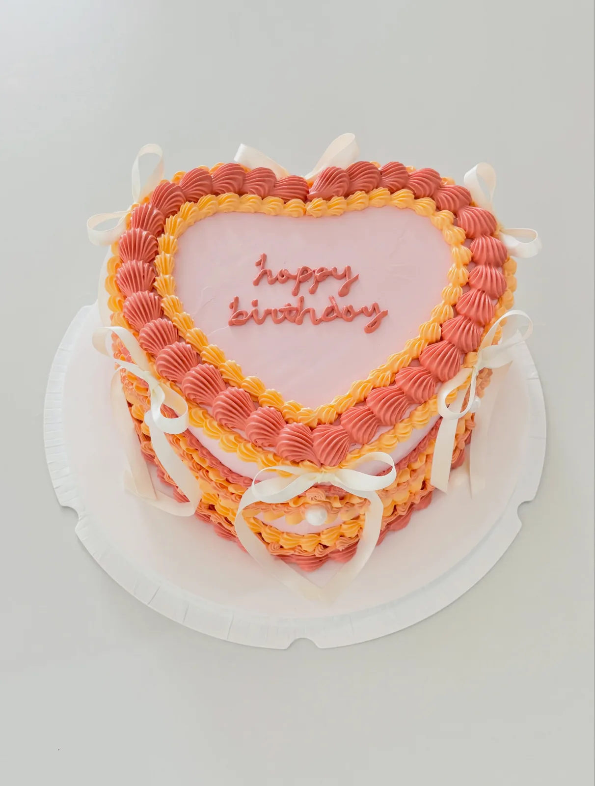 Coral and pink heart cake with piped borders, bespoke celebration cake from Danine Cakes, South London