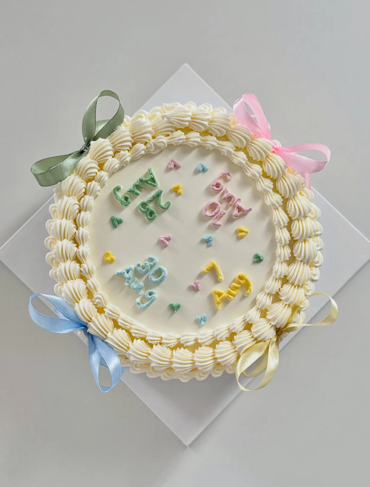 Cream cake with pastel confetti and ribbons, handmade to order by Danine Cakes in Streatham, South London