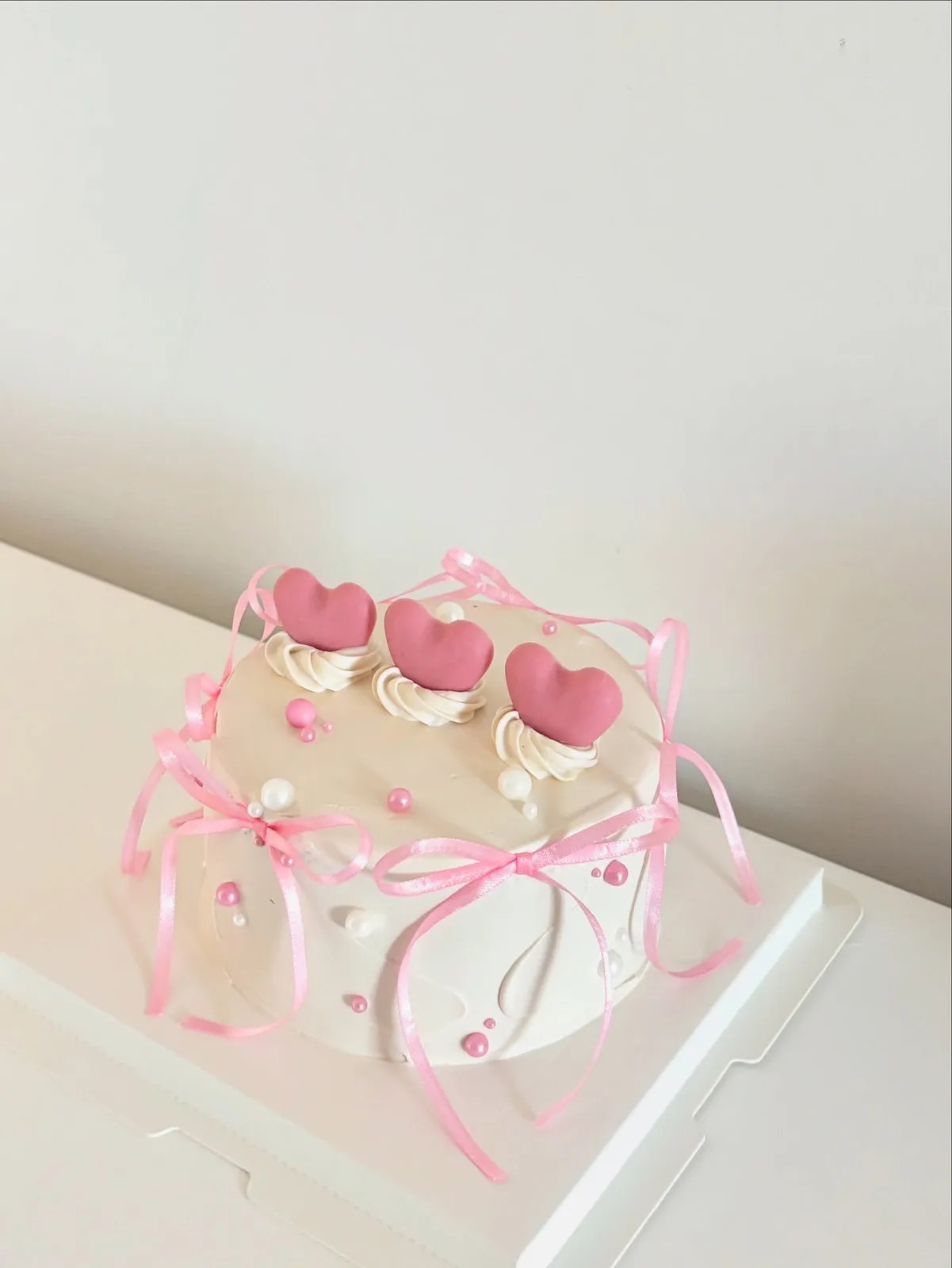 Cream cake with pink hearts and satin ribbons, custom cake made in Streatham SW16 - Danine Cakes