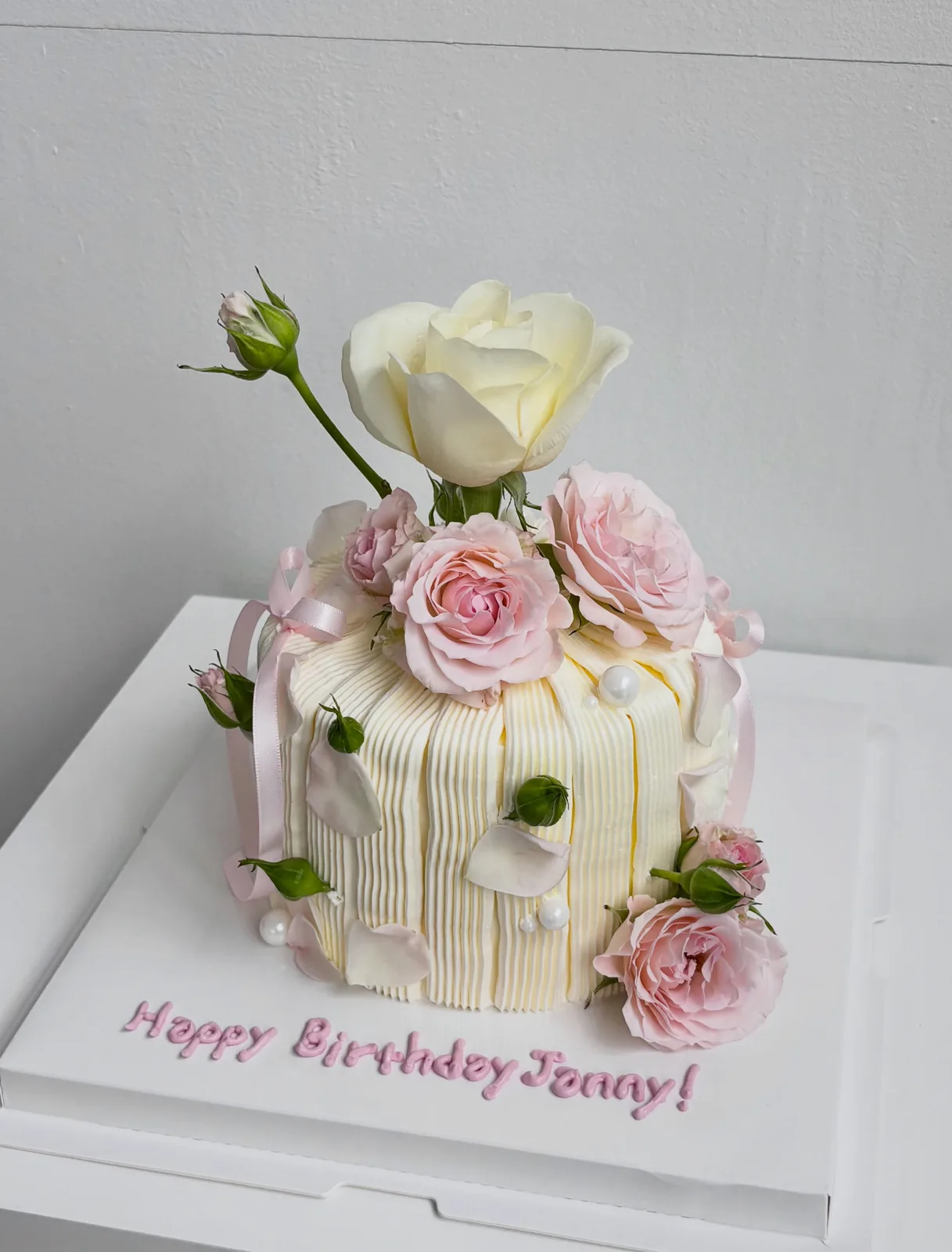 Cream piped strand cake with fresh roses and white rose, bespoke celebration cake from Danine Cakes, South London