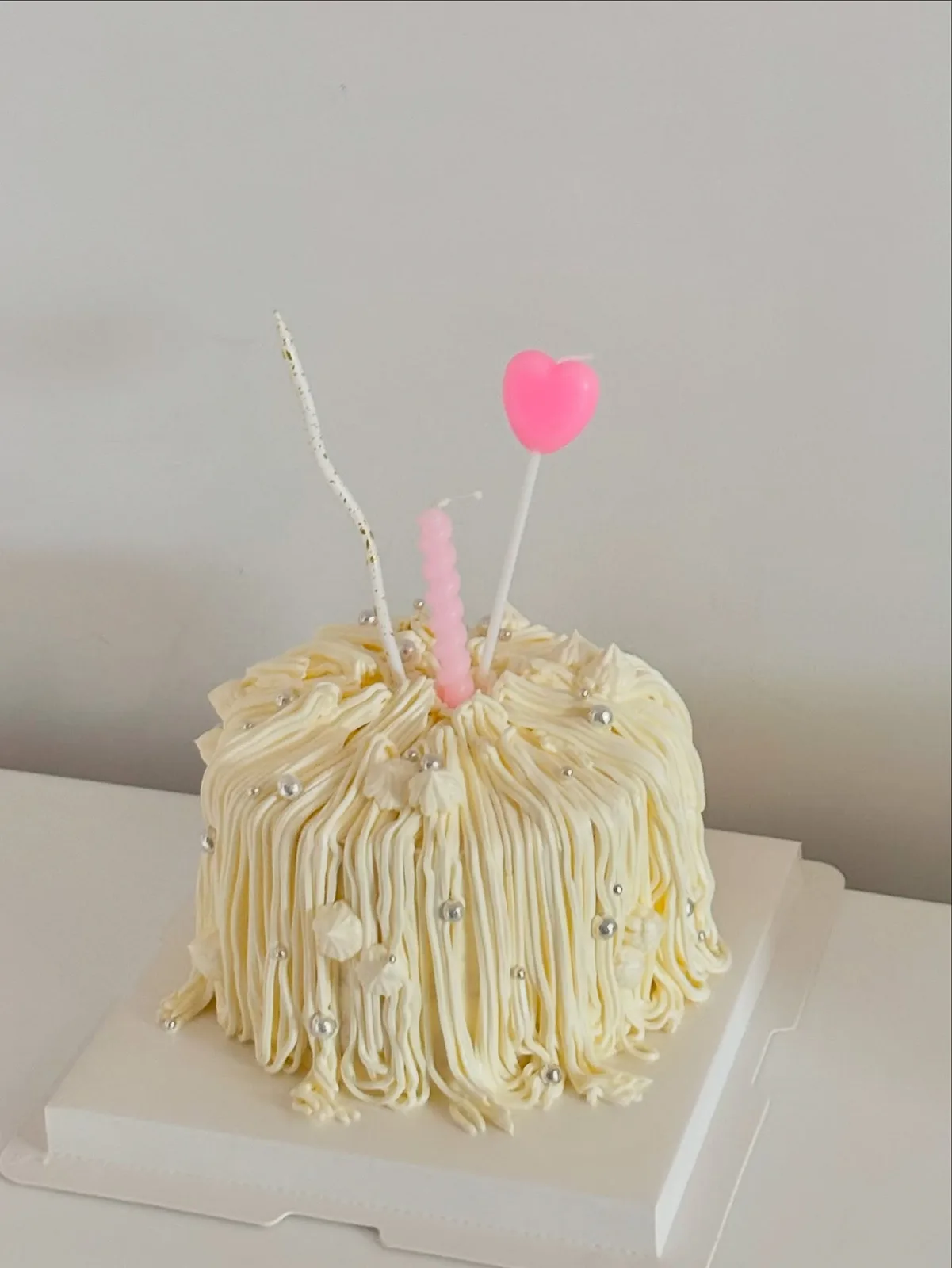 Cream piped strand cake with pink heart candle and pearls, Korean-inspired custom cake handmade in Streatham, London