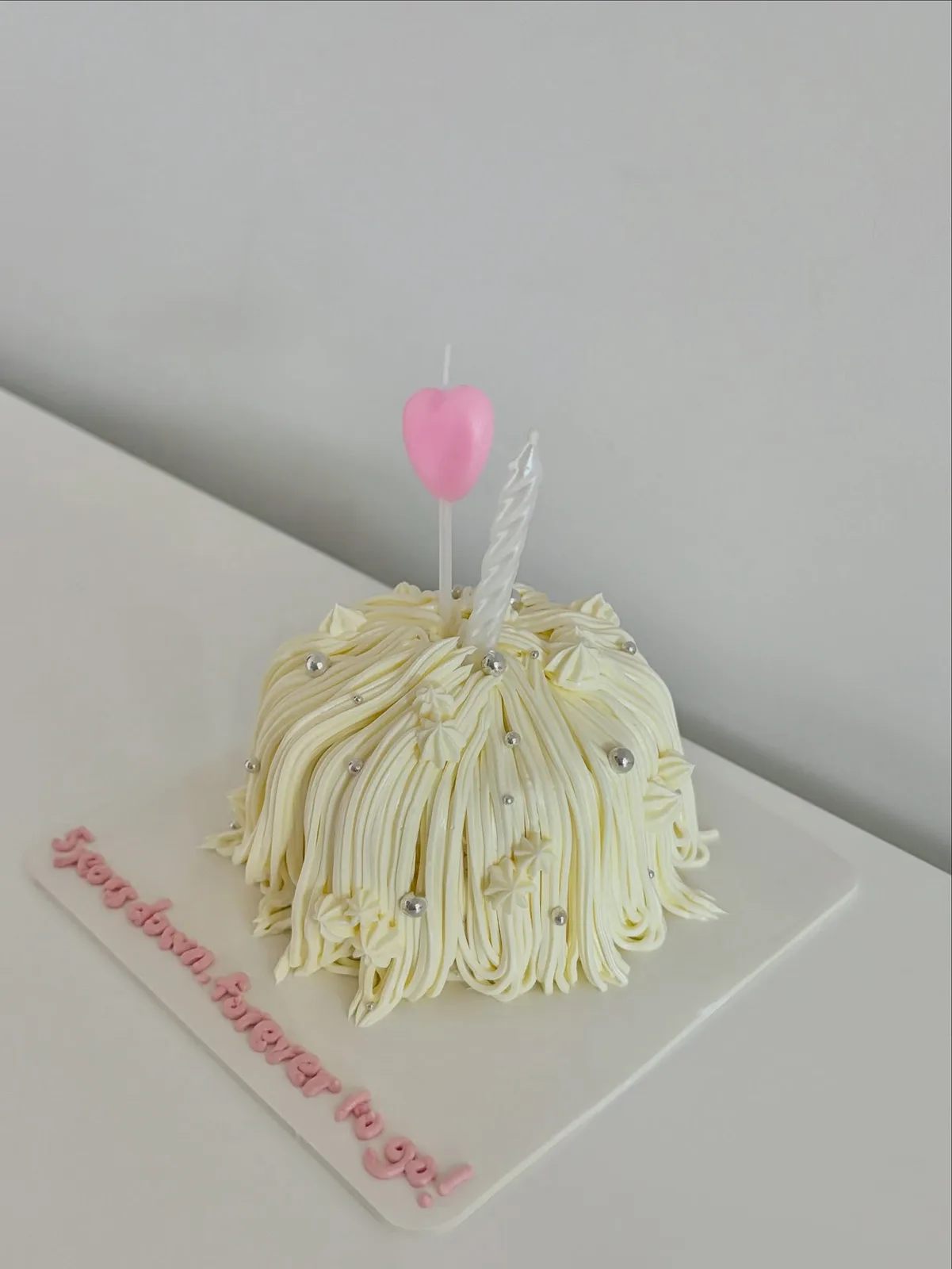 Cream piped strand cake with pink heart candle, Korean-inspired custom cake handmade in Streatham, London