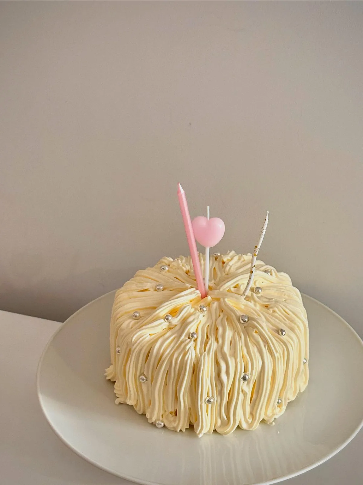 Cream piped strand cake with pink heart candle, Korean-inspired custom cake handmade in Streatham, London