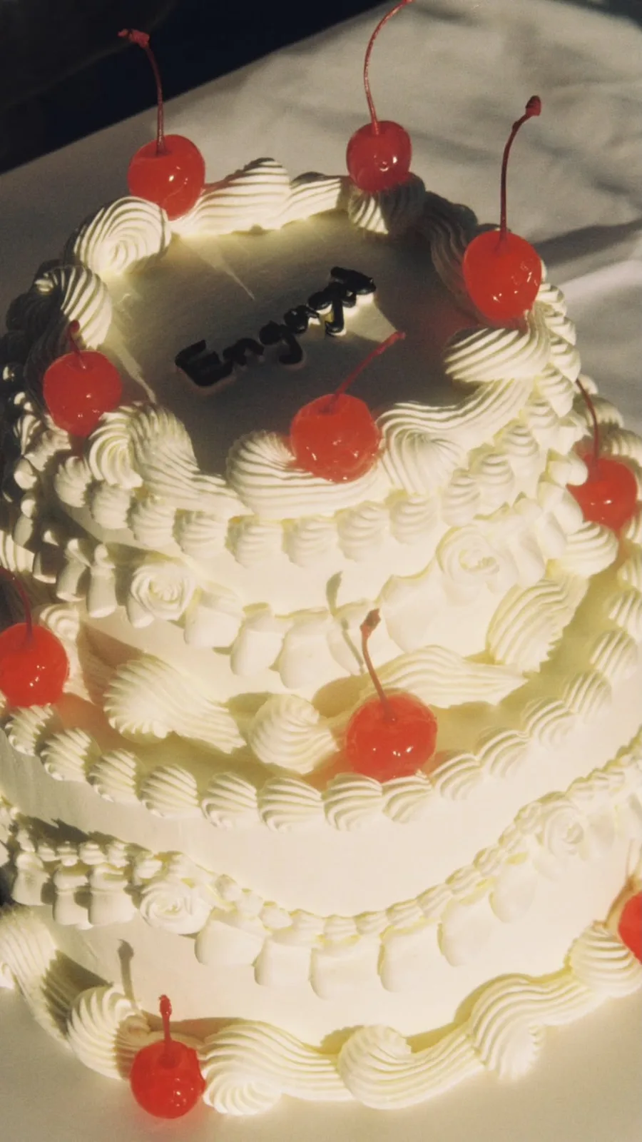 Cream tiered cake with cherries and piped shells, bespoke celebration cake from Danine Cakes, South London