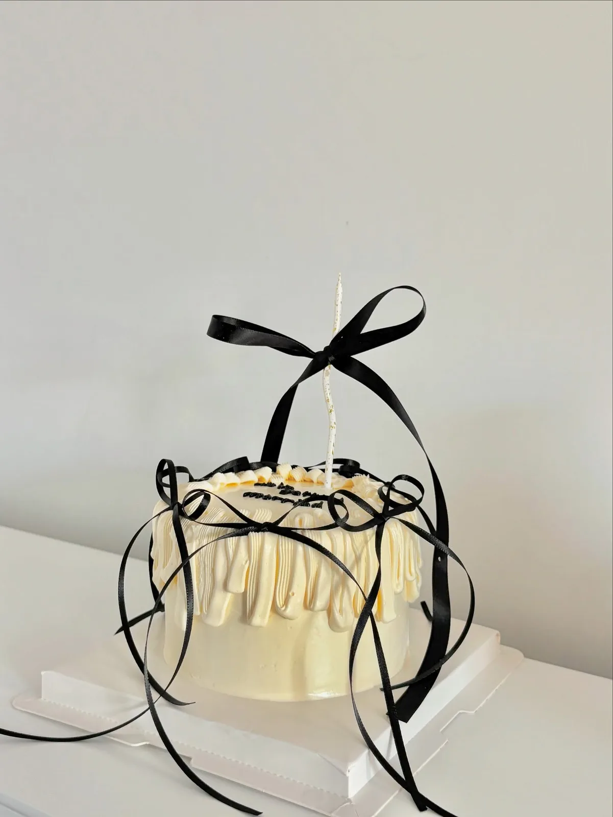 Ivory piped strand cake with black ribbon, Korean-inspired custom cake handmade in Streatham, London