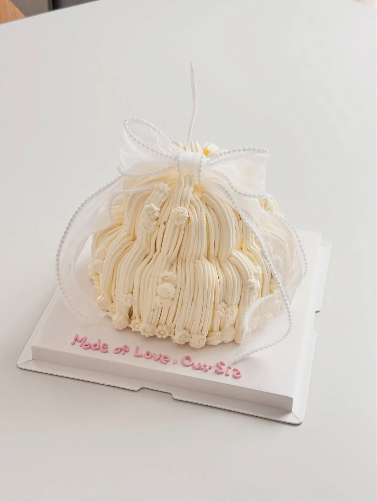 Ivory piped strand cake with organza bow, Korean-inspired custom cake handmade in Streatham, London