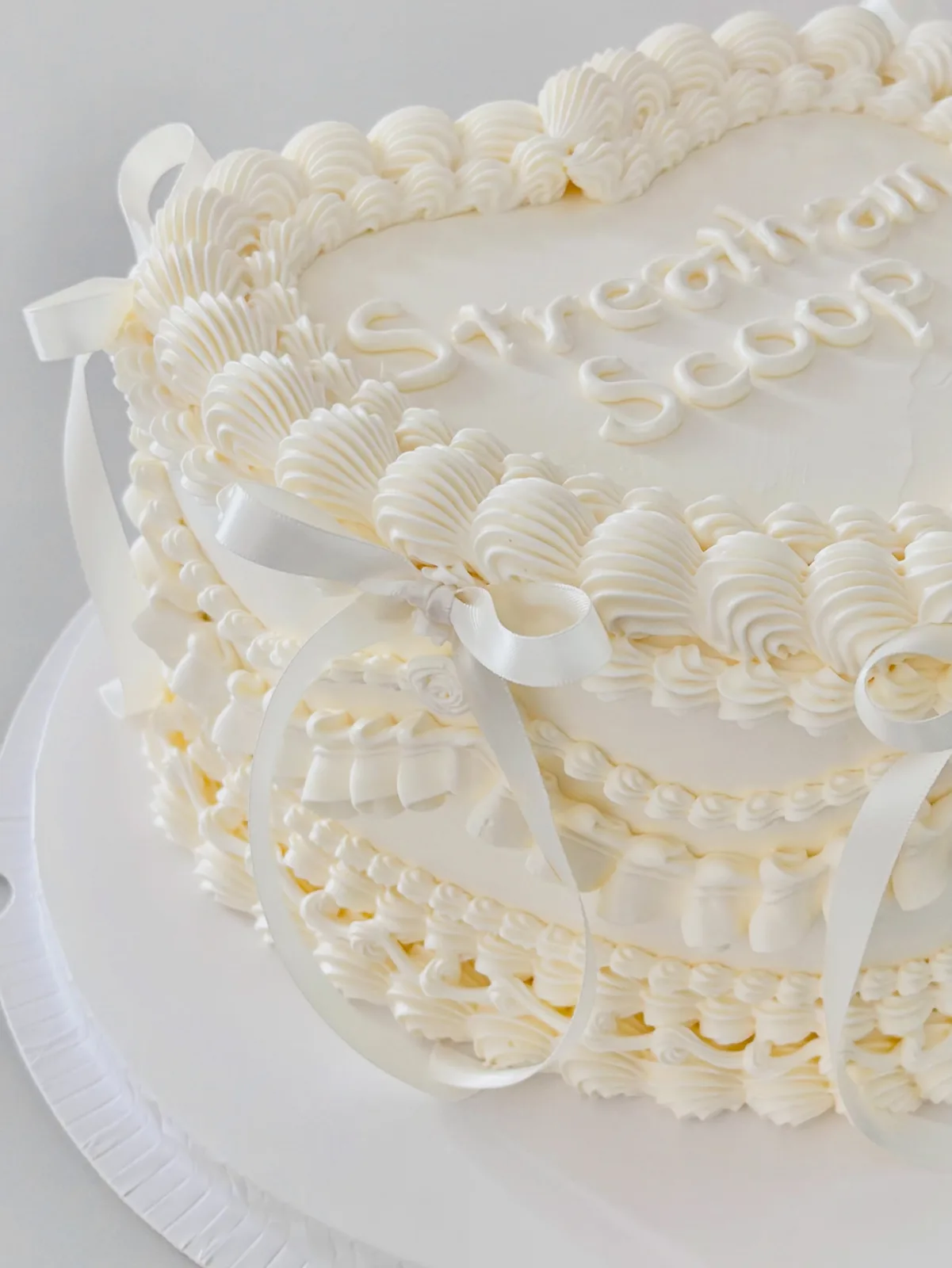 Ivory tiered cake with piped shells and lettering, bespoke celebration cake from Danine Cakes, South London