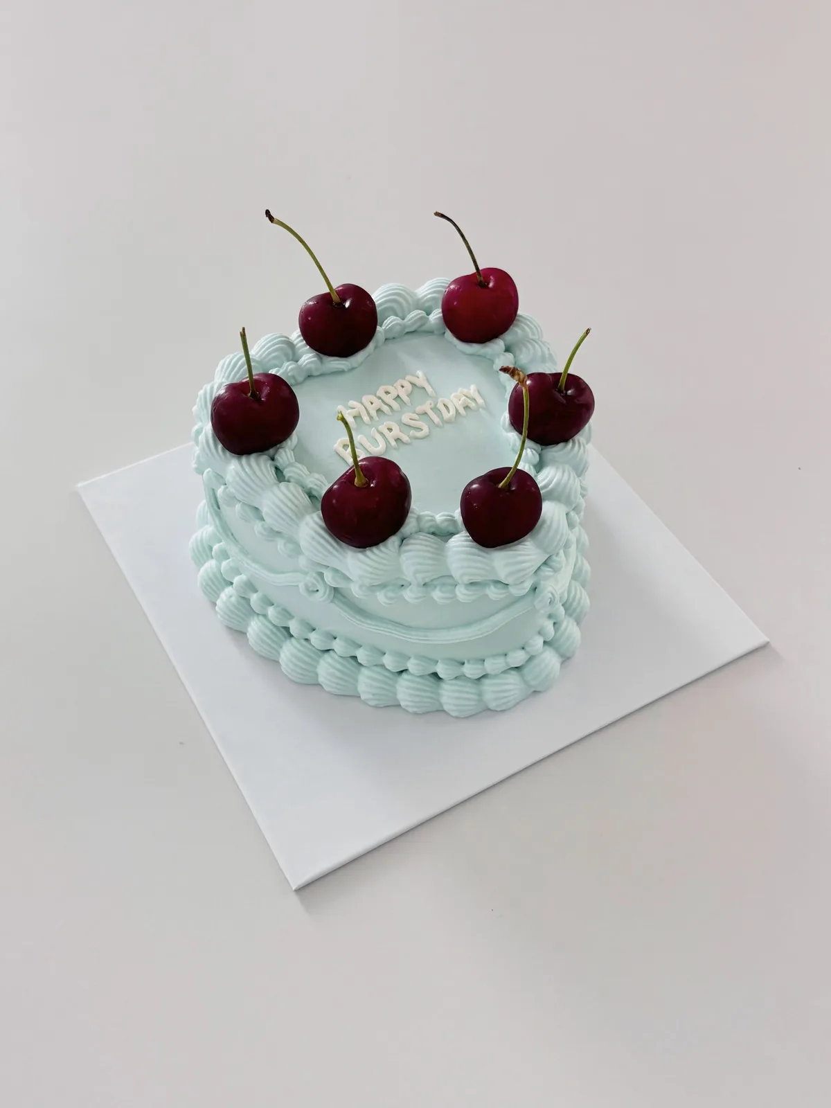 Mint green cake with cherries and piped pearls, bespoke celebration cake from Danine Cakes, South London