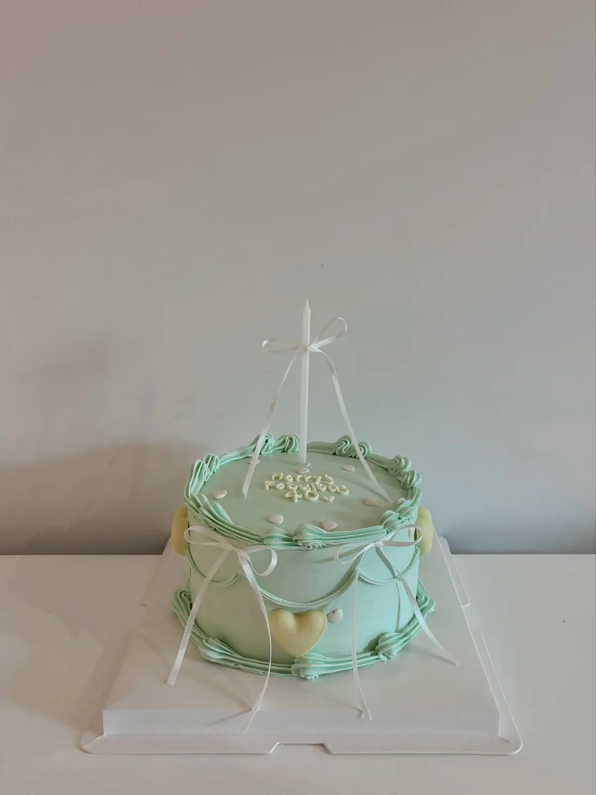 Mint green cake with piped border and ribbon, bespoke celebration cake from Danine Cakes, South London