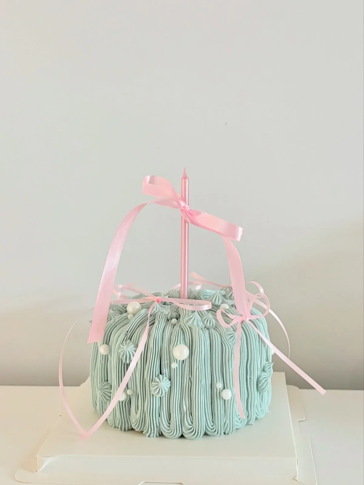 Mint piped strand cake with pink ribbon bows, Korean-inspired custom cake handmade in Streatham, London