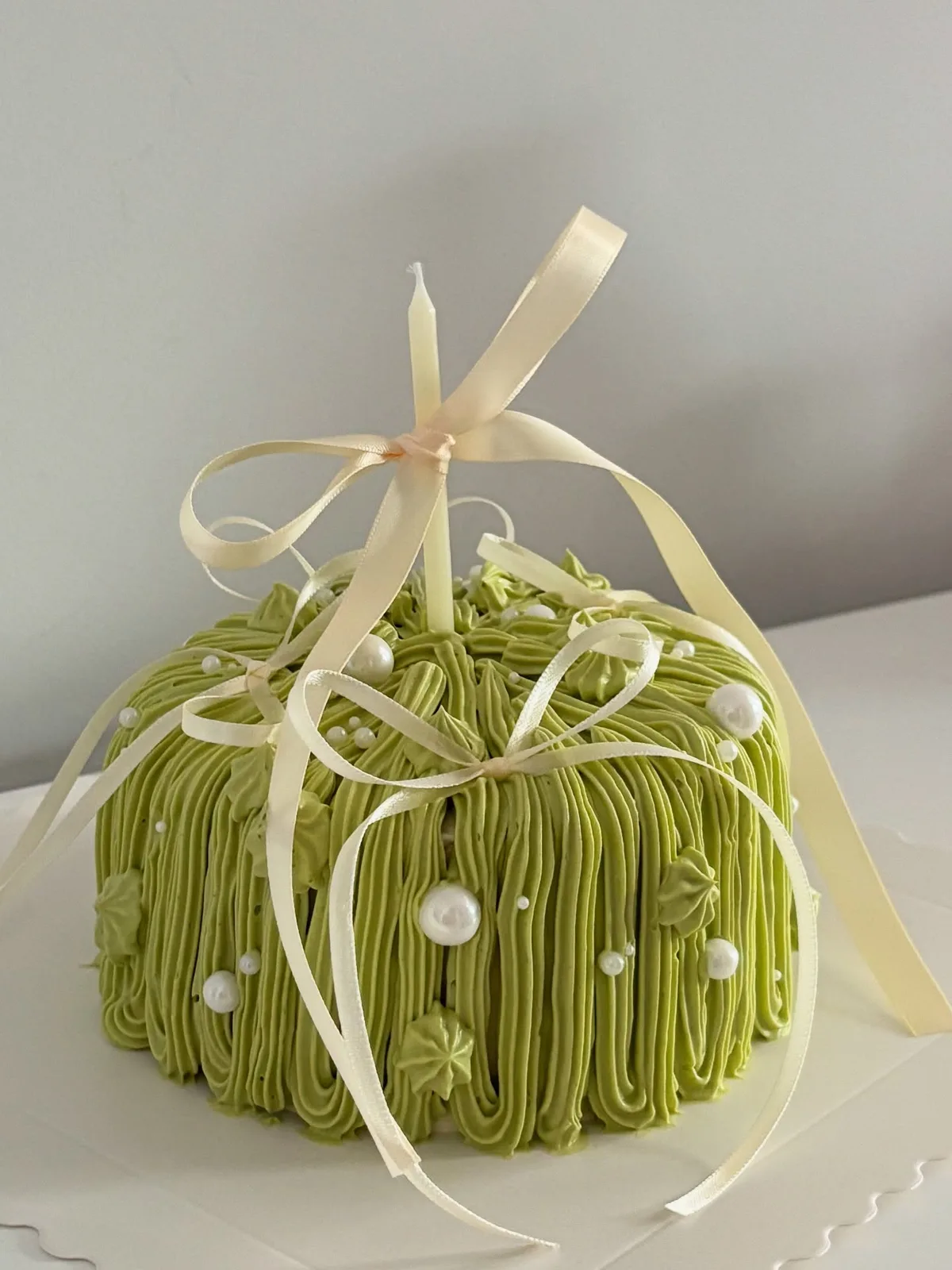 Olive green piped strand cake with cream ribbon, bespoke celebration cake from Danine Cakes, South London