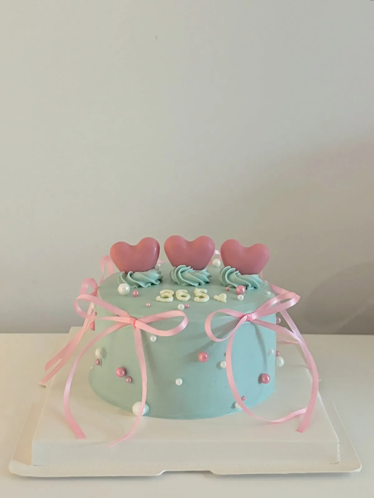 Pale blue cake with pink hearts, bows and pearls, Korean-inspired custom cake handmade in Streatham, London