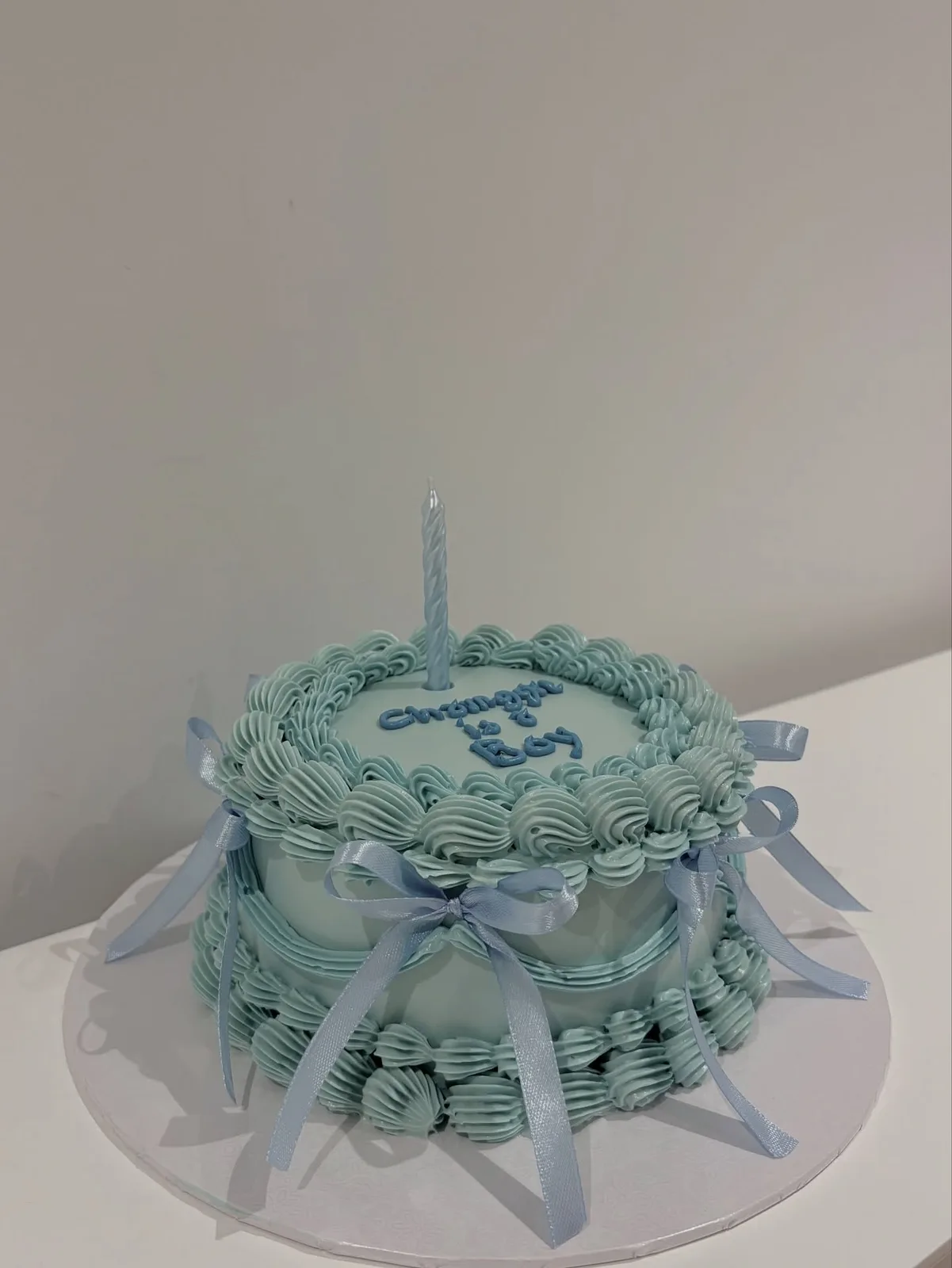 Pale blue cake with white bows and piped border, custom cake made in Streatham SW16 - Danine Cakes