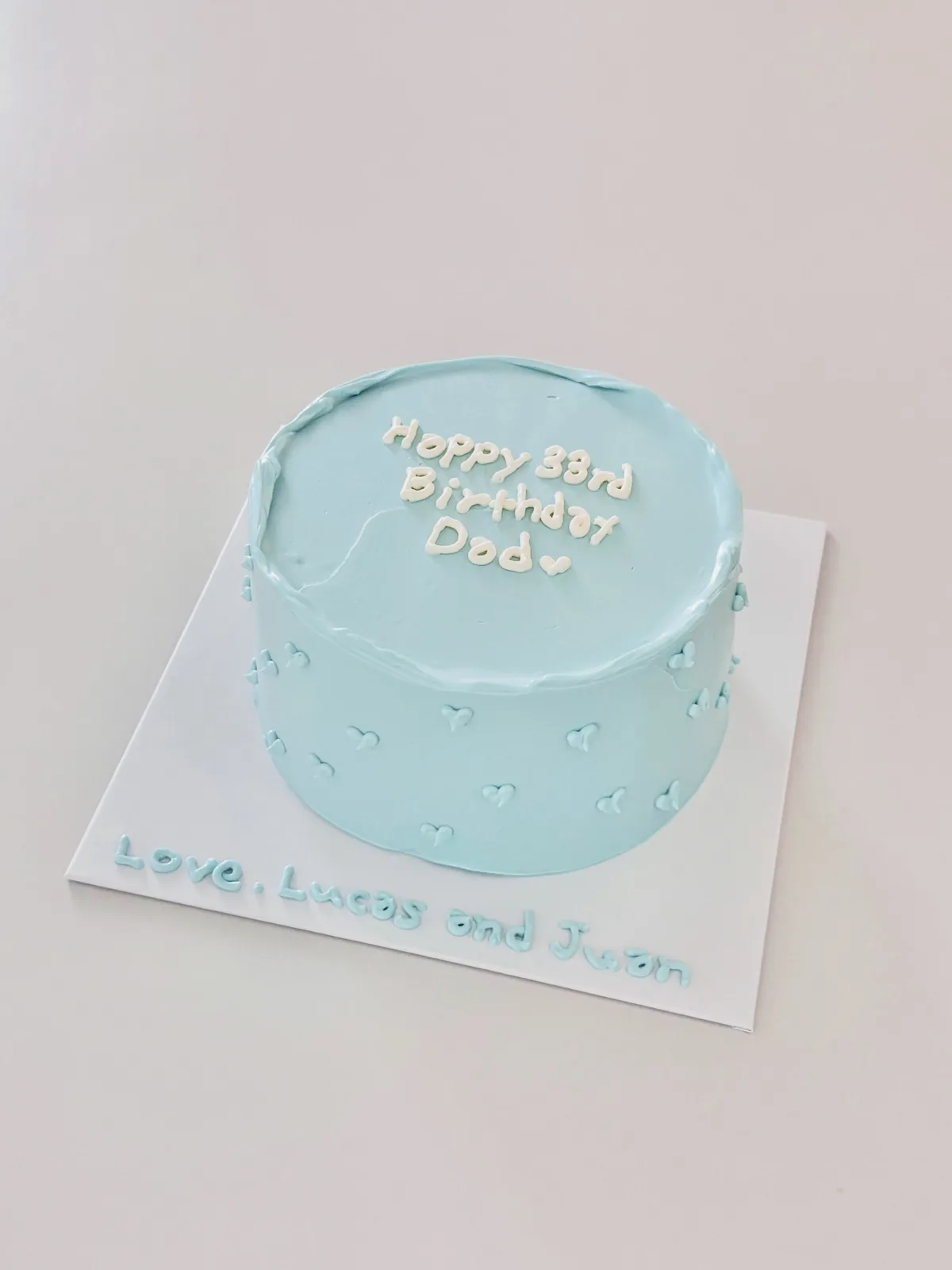 Pale blue cake with white dots and piped lettering, custom cake made in Streatham SW16 - Danine Cakes