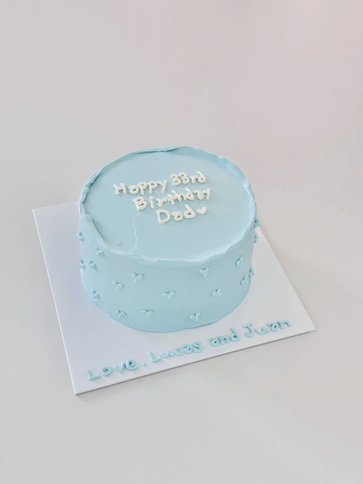 Pale blue cake with white dots and piped lettering, Korean-inspired custom cake handmade in Streatham, London