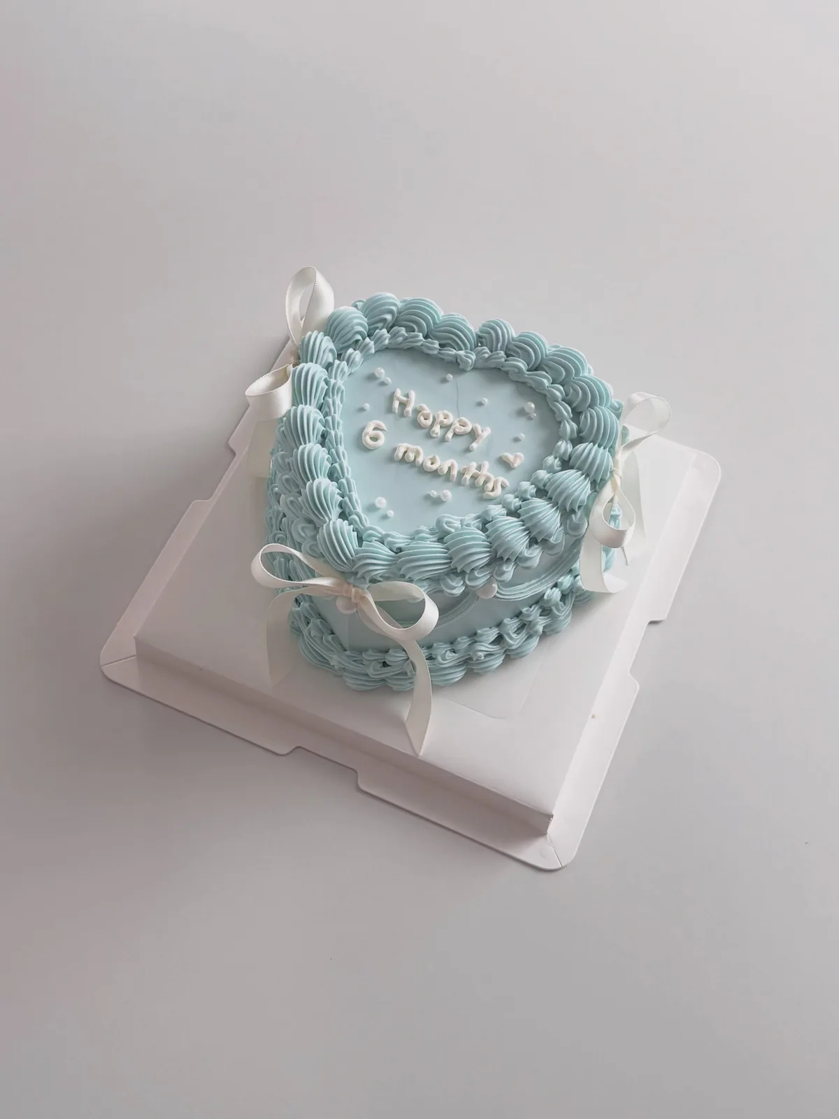 Pale blue heart cake with piped border and bows, Korean-inspired custom cake handmade in Streatham, London