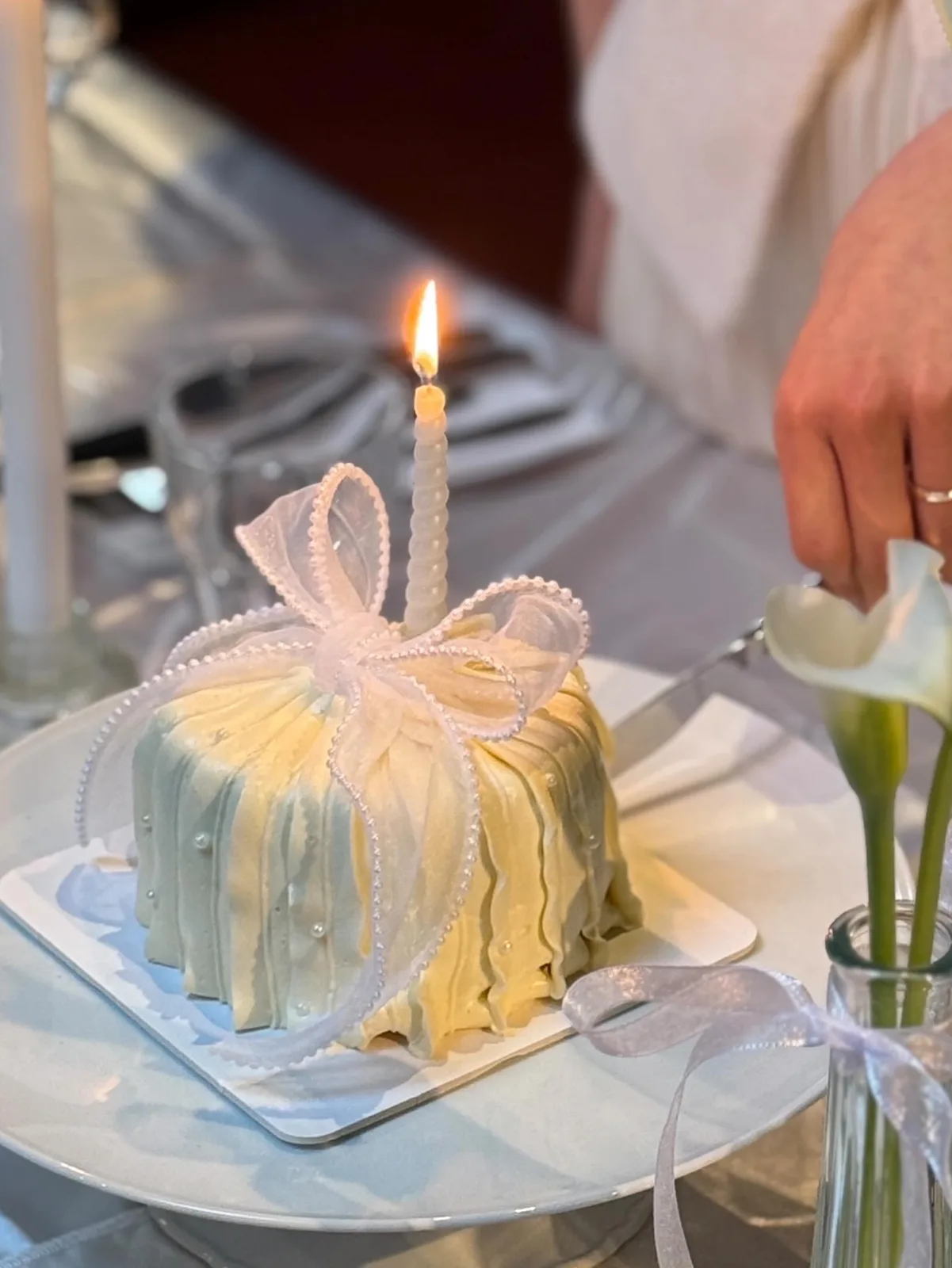 Pale blue piped cake with pink bow and candle, custom cake made in Streatham SW16 - Danine Cakes