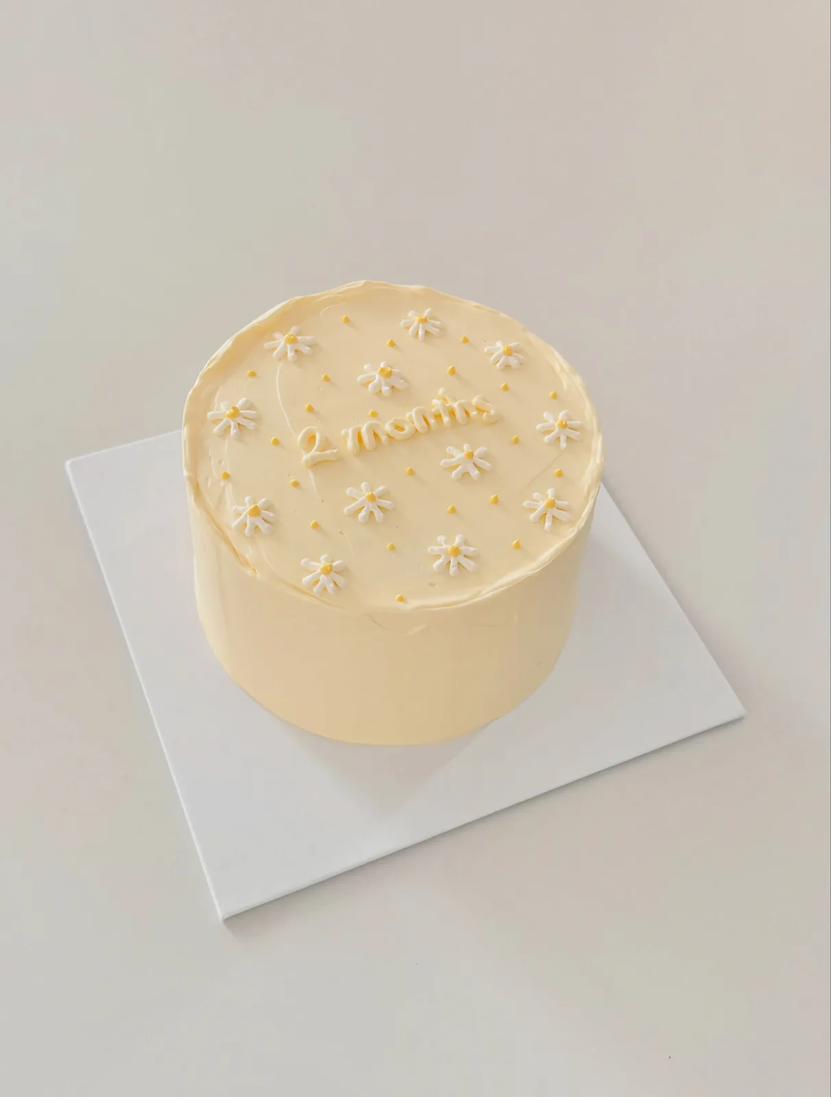 Pale yellow cake with white piped daisies, Korean-inspired custom cake handmade in Streatham, London