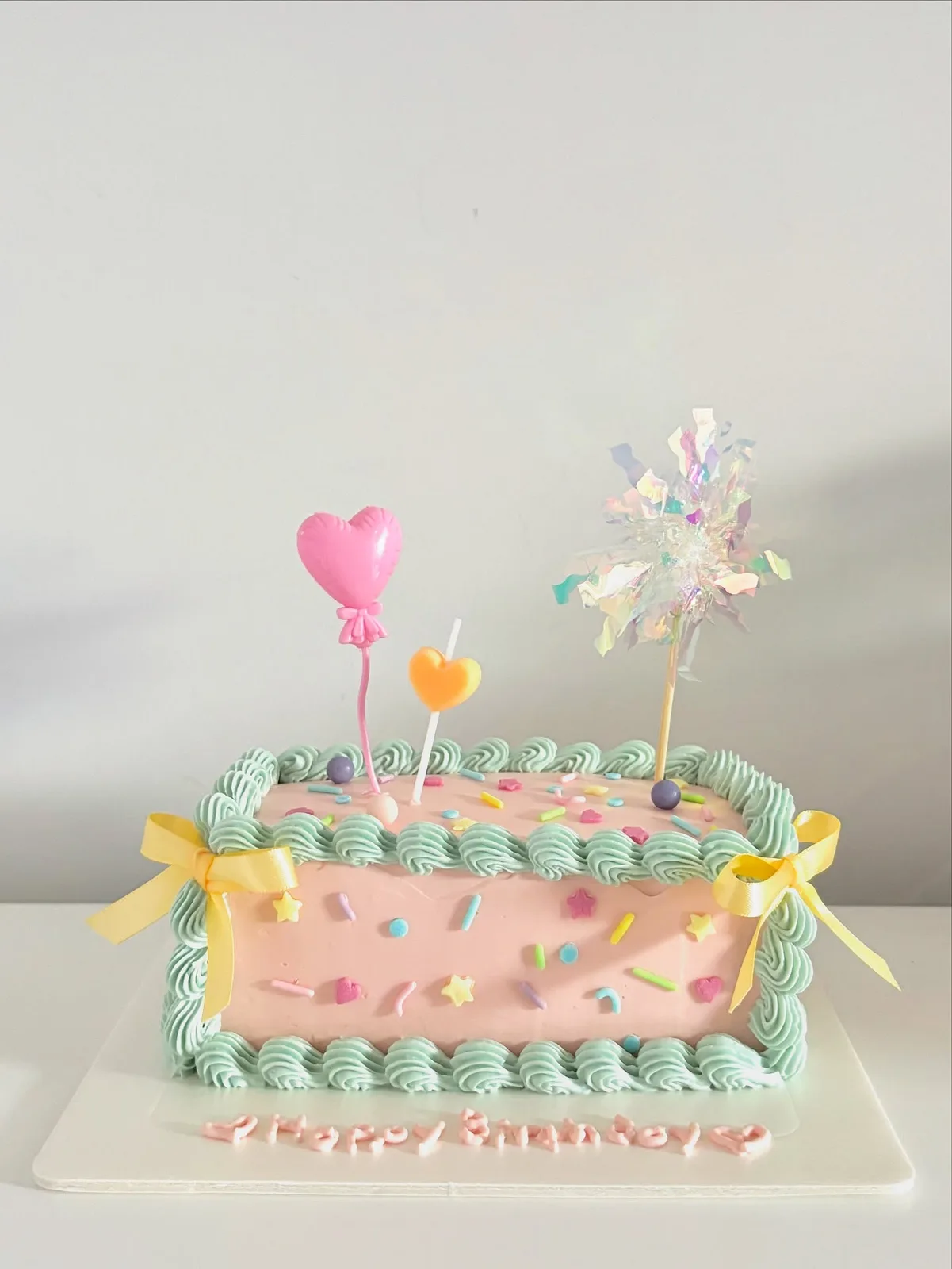 Pastel cake with balloon picks and piped border, Korean-inspired custom cake handmade in Streatham, London