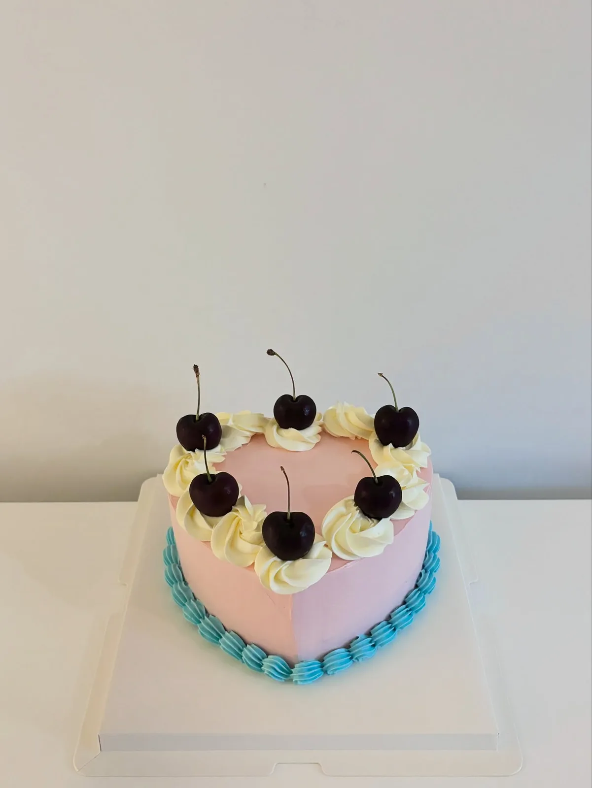 Pastel cake with dark cherries and piped cream, Korean-inspired custom cake handmade in Streatham, London