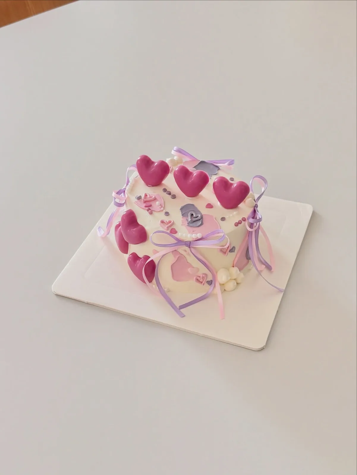 Pastel cake with pink hearts and ribbon streamers, bespoke celebration cake from Danine Cakes, South London