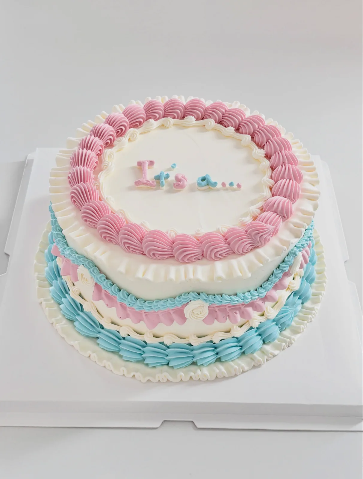 Pink and blue layered cake with piped shells, bespoke celebration cake from Danine Cakes, South London
