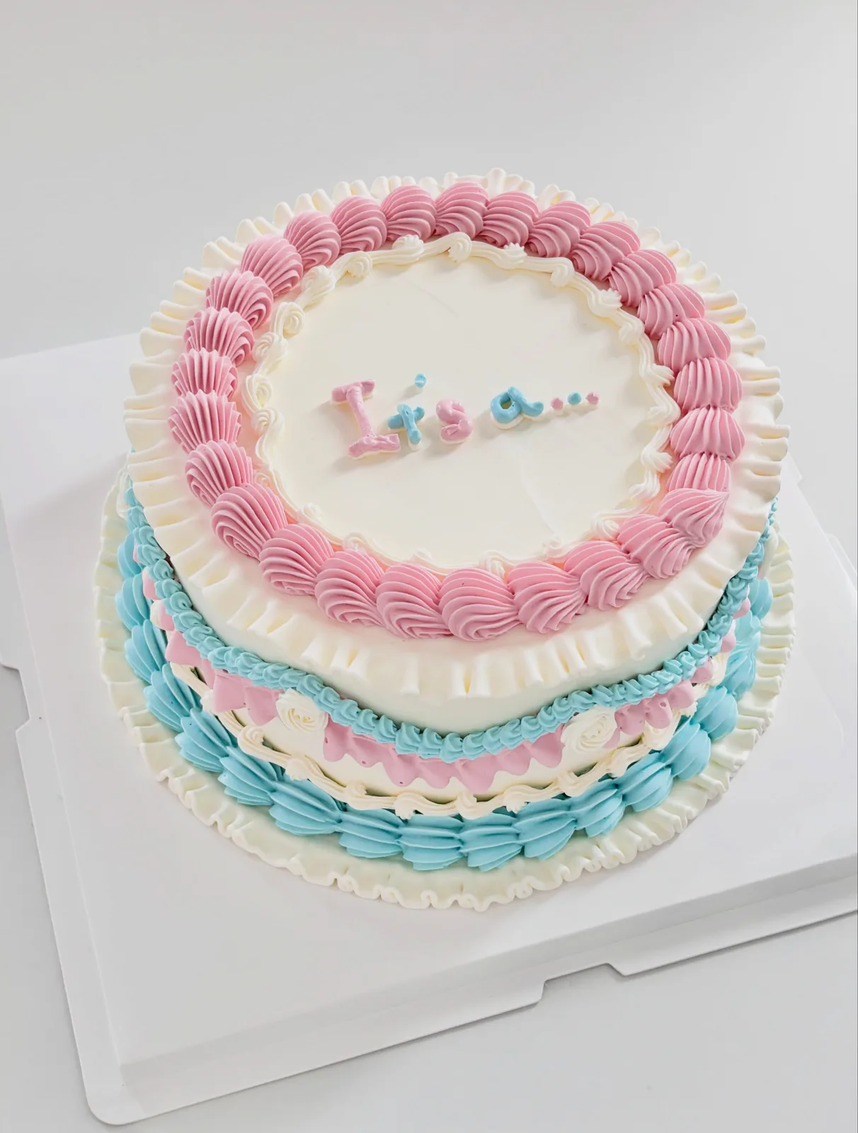Pink and blue layered cake with piped shells, bespoke celebration cake from Danine Cakes, South London