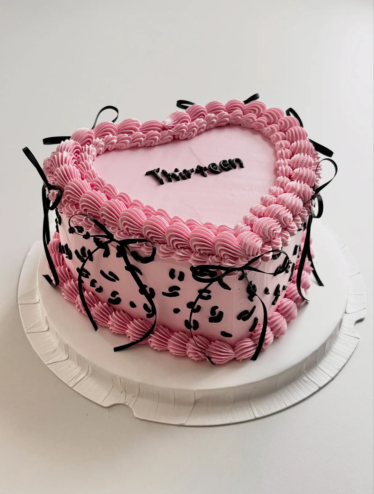 Pink heart cake with black bows and leopard print piping, custom cake made in Streatham SW16 - Danine Cakes