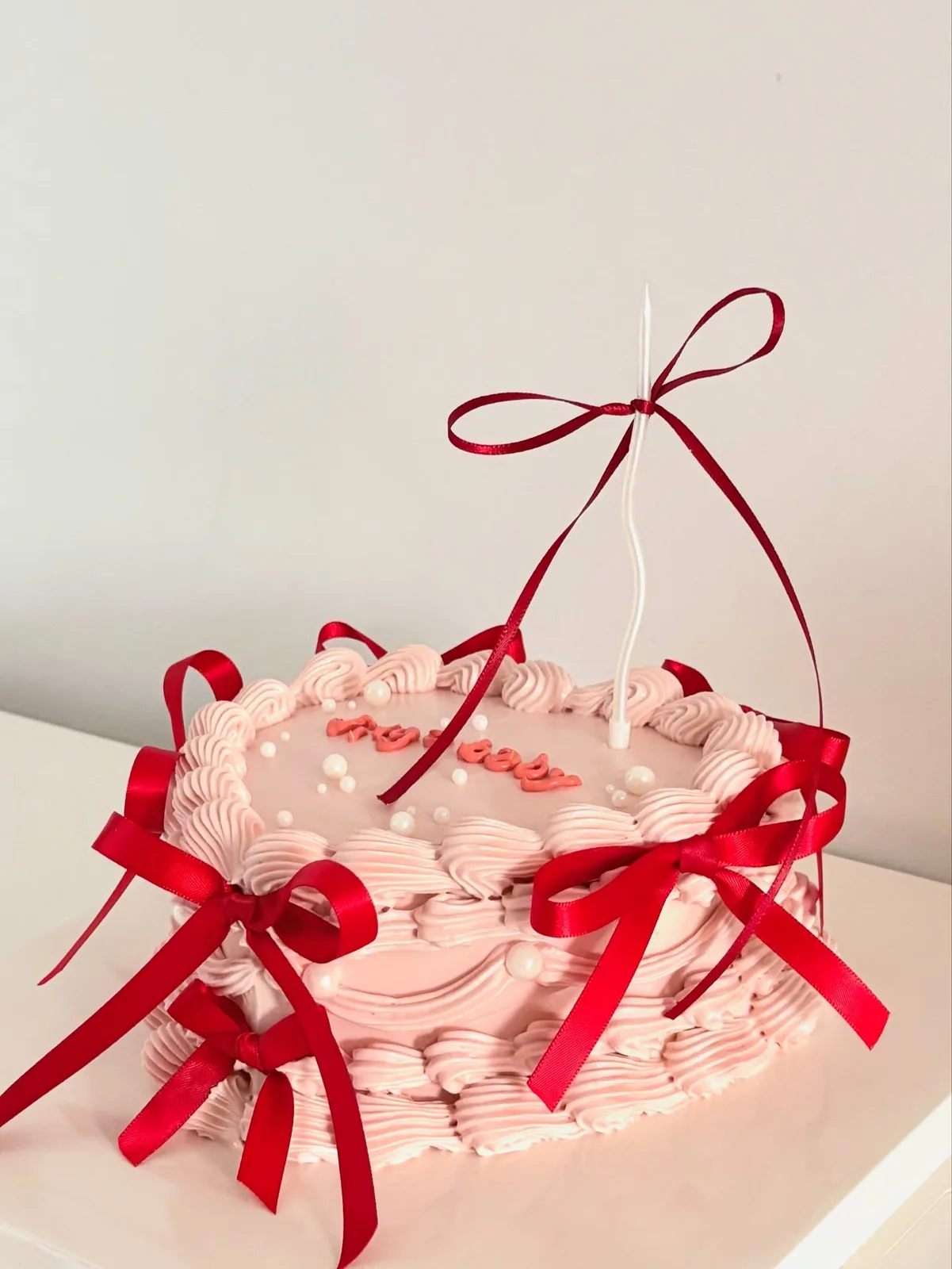 Pink piped ruffle cake with red ribbon bow, Korean-inspired custom cake handmade in Streatham, London