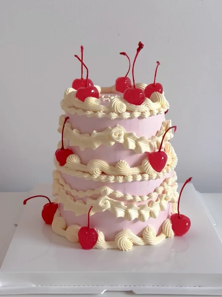 Three tier pink and cream cake with cherries, handmade to order by Danine Cakes in Streatham, South London