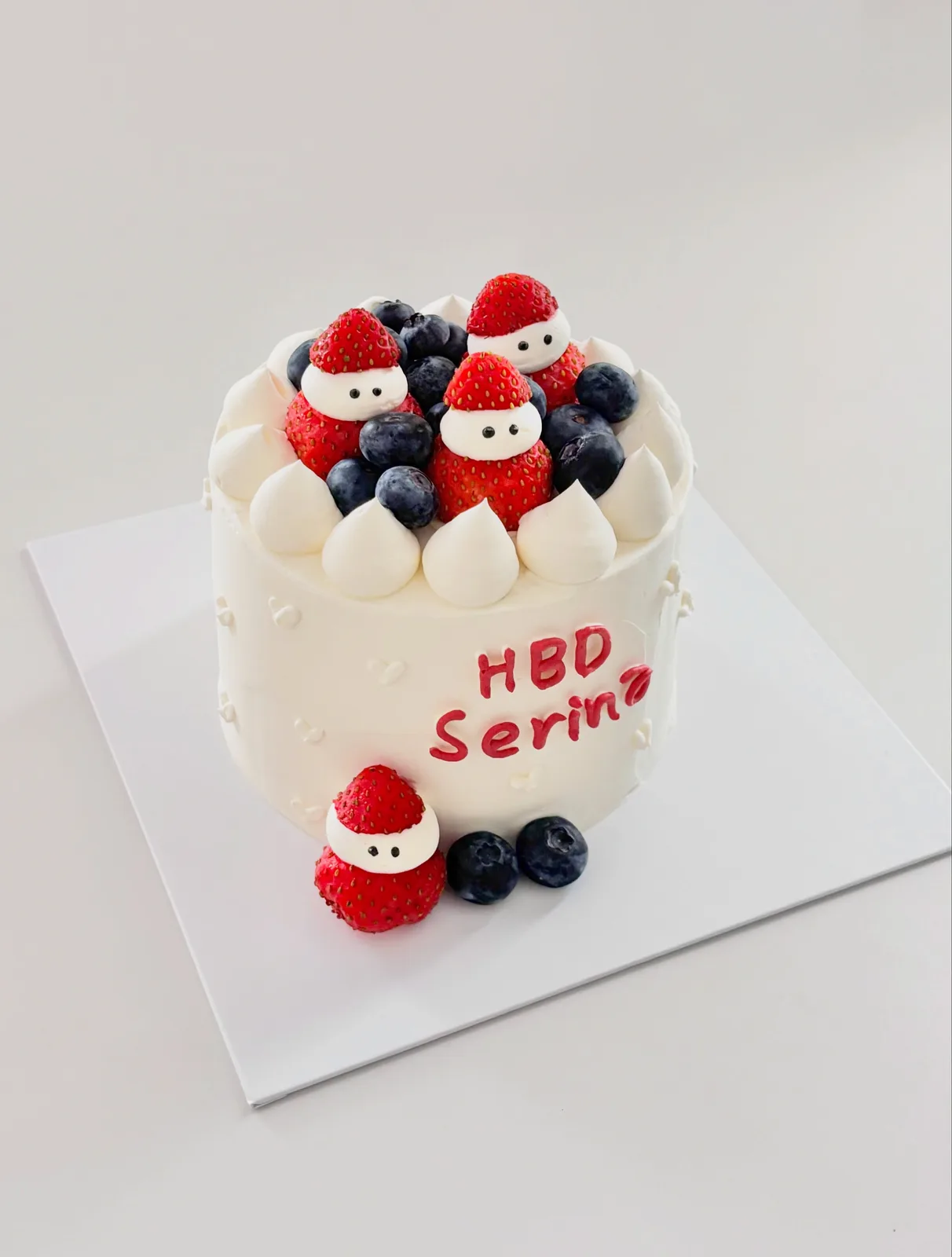 White cake with strawberries, blueberries and Santa figures, custom cake made in Streatham SW16 - Danine Cakes