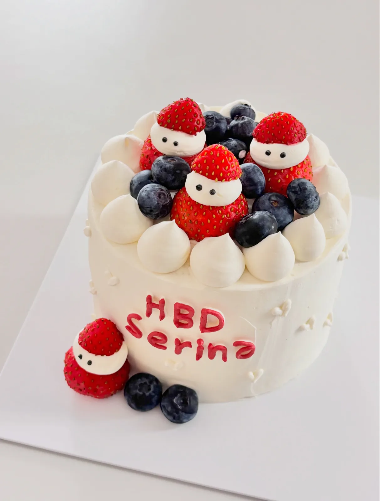 White cake with strawberries, blueberries and Santa figures, Korean-inspired custom cake handmade in Streatham, London
