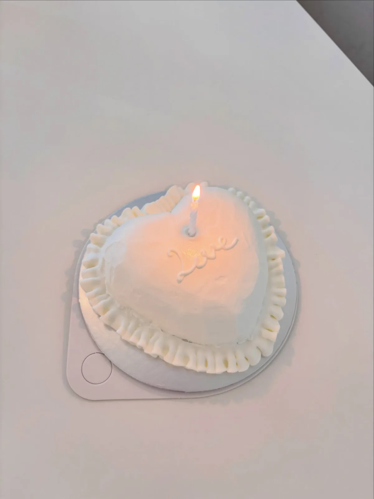 White heart cake with piped border and candlelight, handmade to order by Danine Cakes in Streatham, South London
