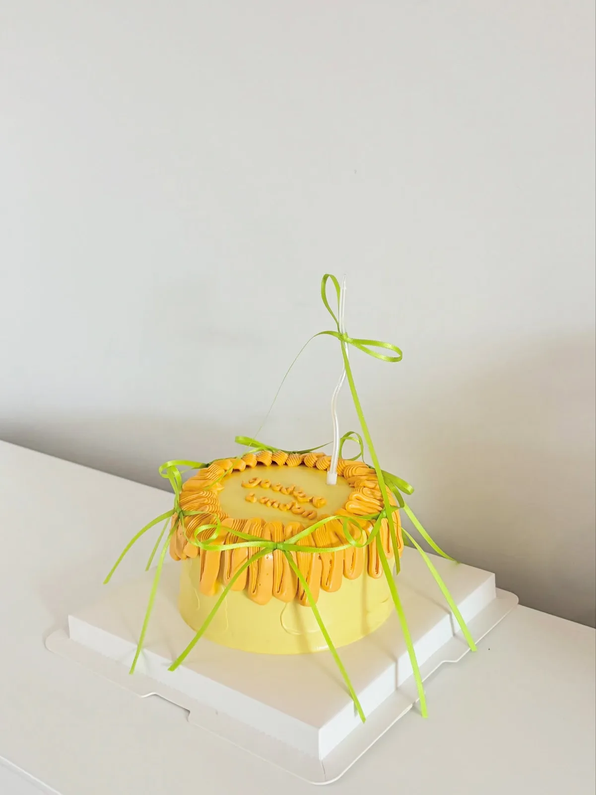 Yellow piped strand cake with green ribbons, custom cake made in Streatham SW16 - Danine Cakes